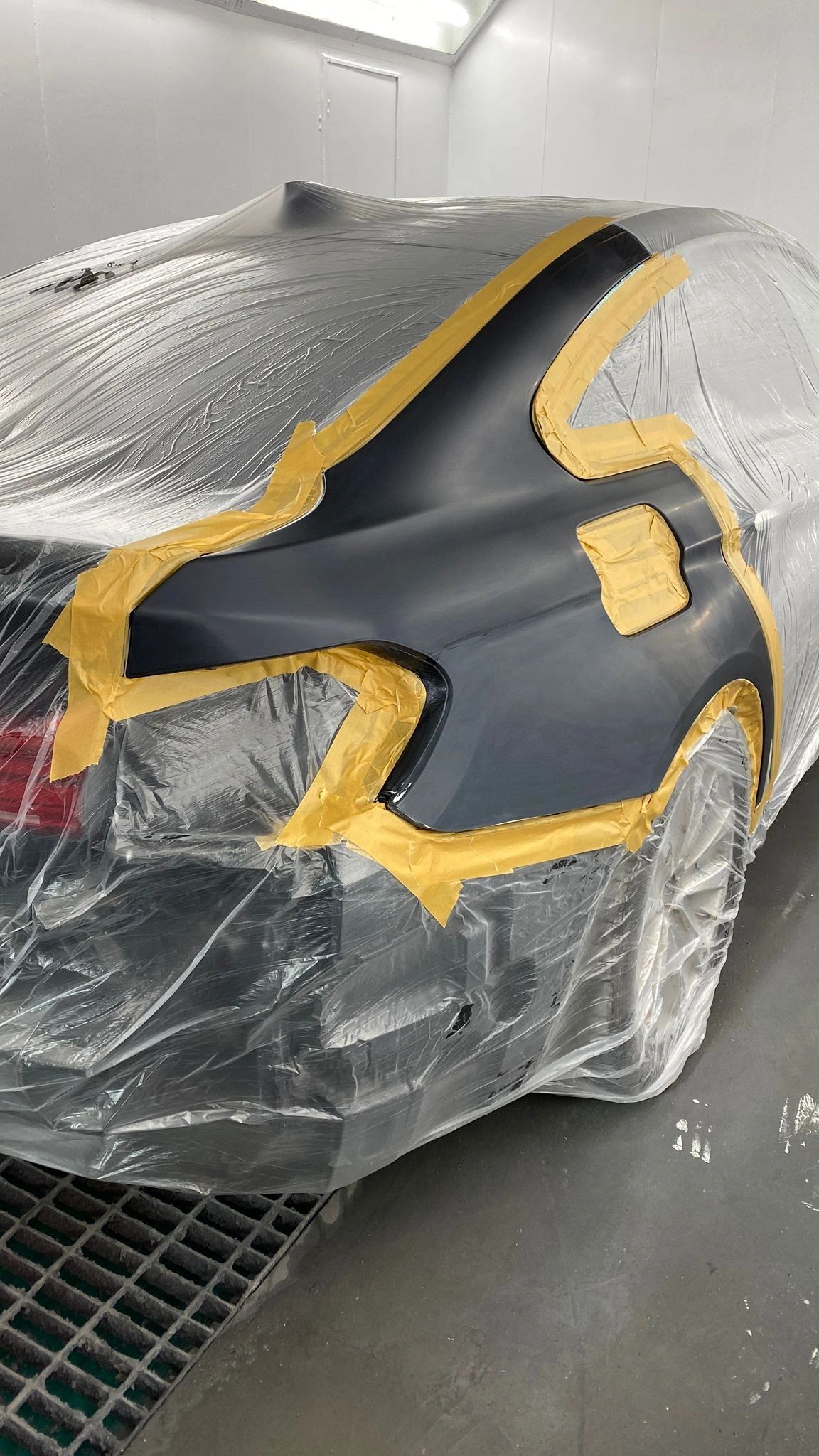 A grey rear quarter panel masked off and prepped before a localised paint repair