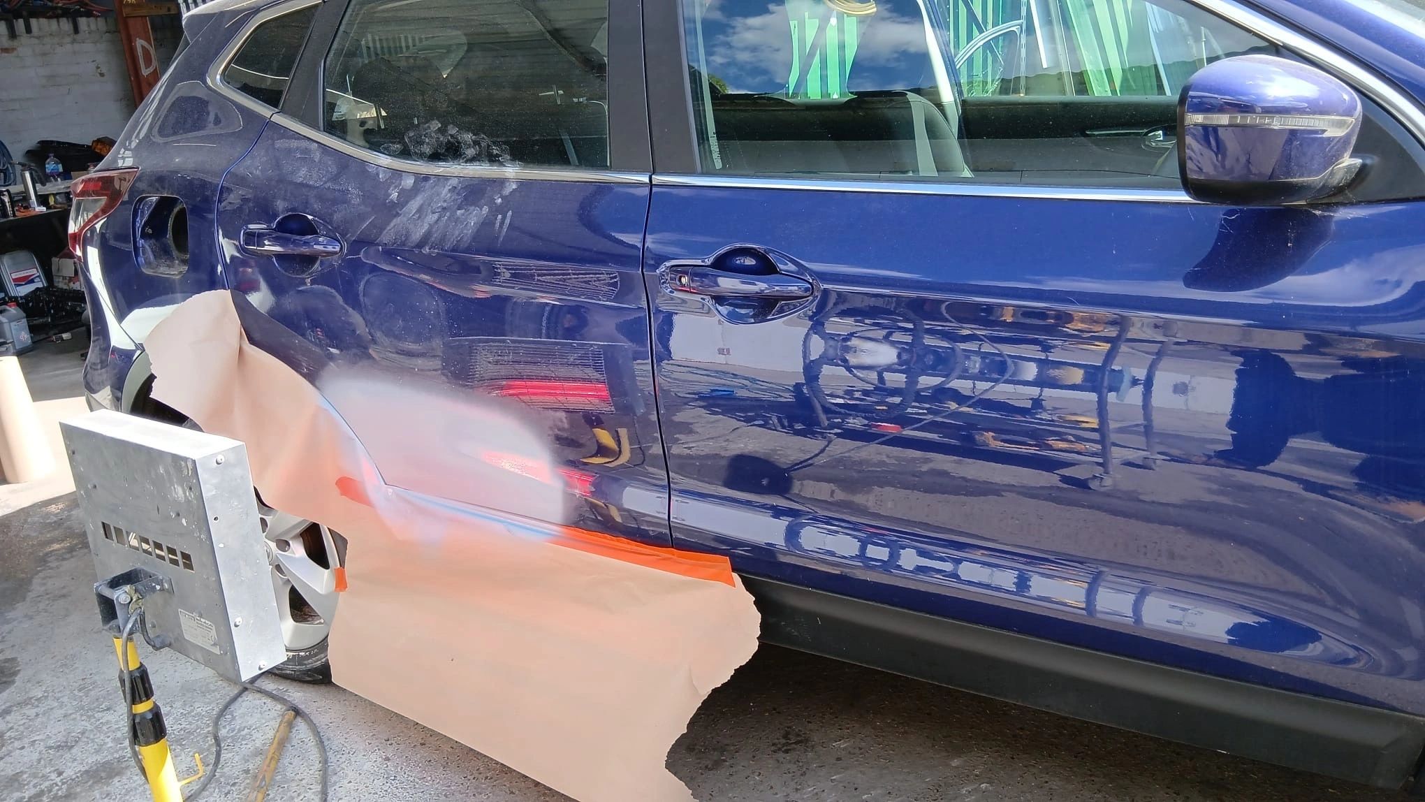 Blue door being sanded back during repair